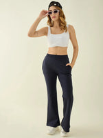 Woman wearing a white crop top, sunglasses, and 98degreenorth navy flared fit bootcut cotton stretchable trousers.