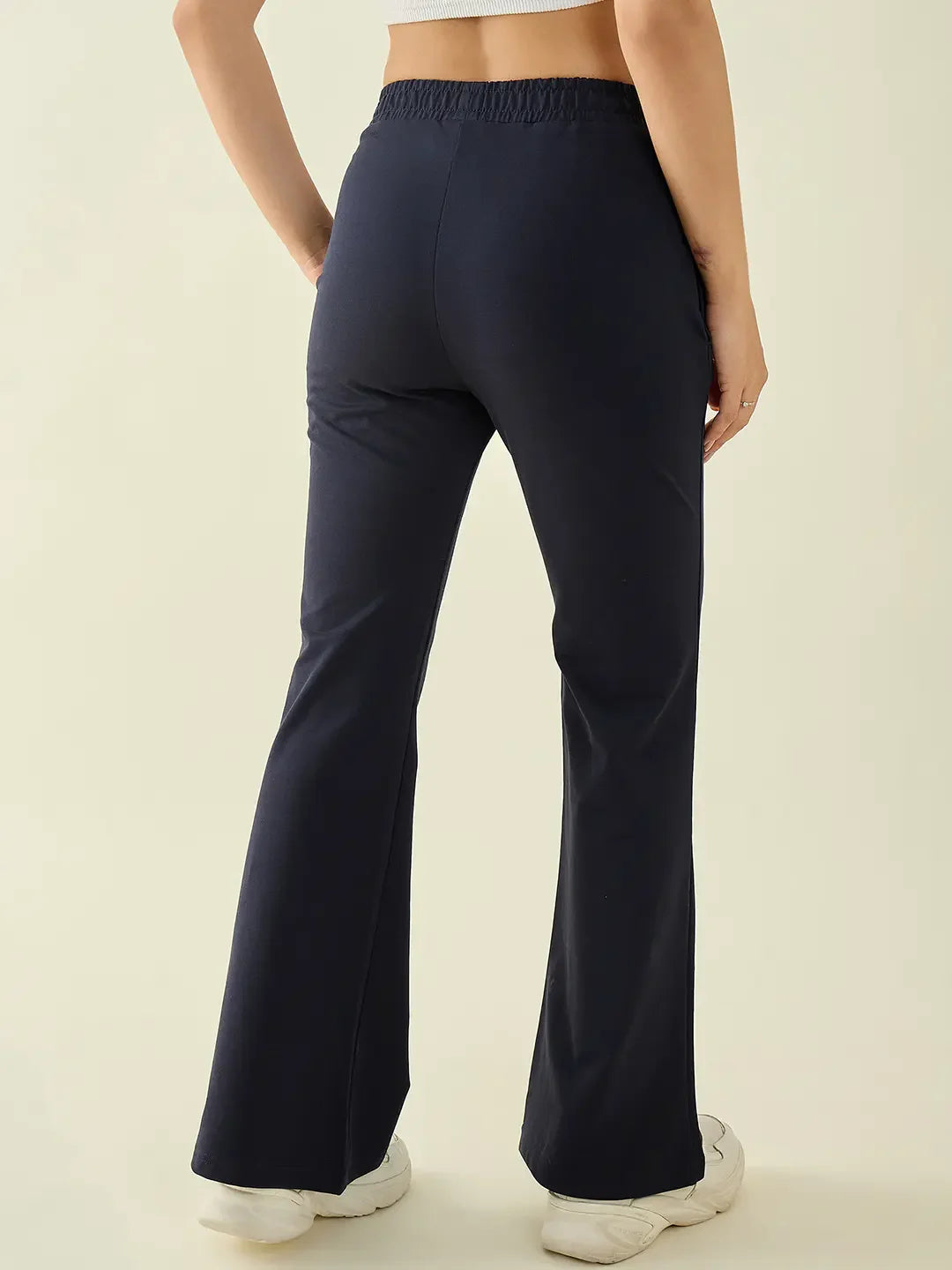 Person seen from the back in 98degreenorth Women’s Navy Flared Fit Bootcut Cotton Trousers, styled with white sneakers.