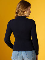 Woman wears 98degreenorth Navy Ribbed Collar Zipper Sweater, slim fit, paired with light blue jeans on yellow backdrop.