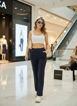 Woman in white crop top and 98degreenorth Women’s Navy Straight Fit Stretchable Trousers walking in a shopping mall.