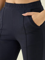 A person wears 98degreenorth Women’s Navy Straight Fit Cotton Stretchable Trousers with their right hand in the pocket.