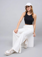 Woman wears 98degreenorth Off-White Bootcut Sweatpants—flared, high-waist lounge pants with side slit—while sitting.