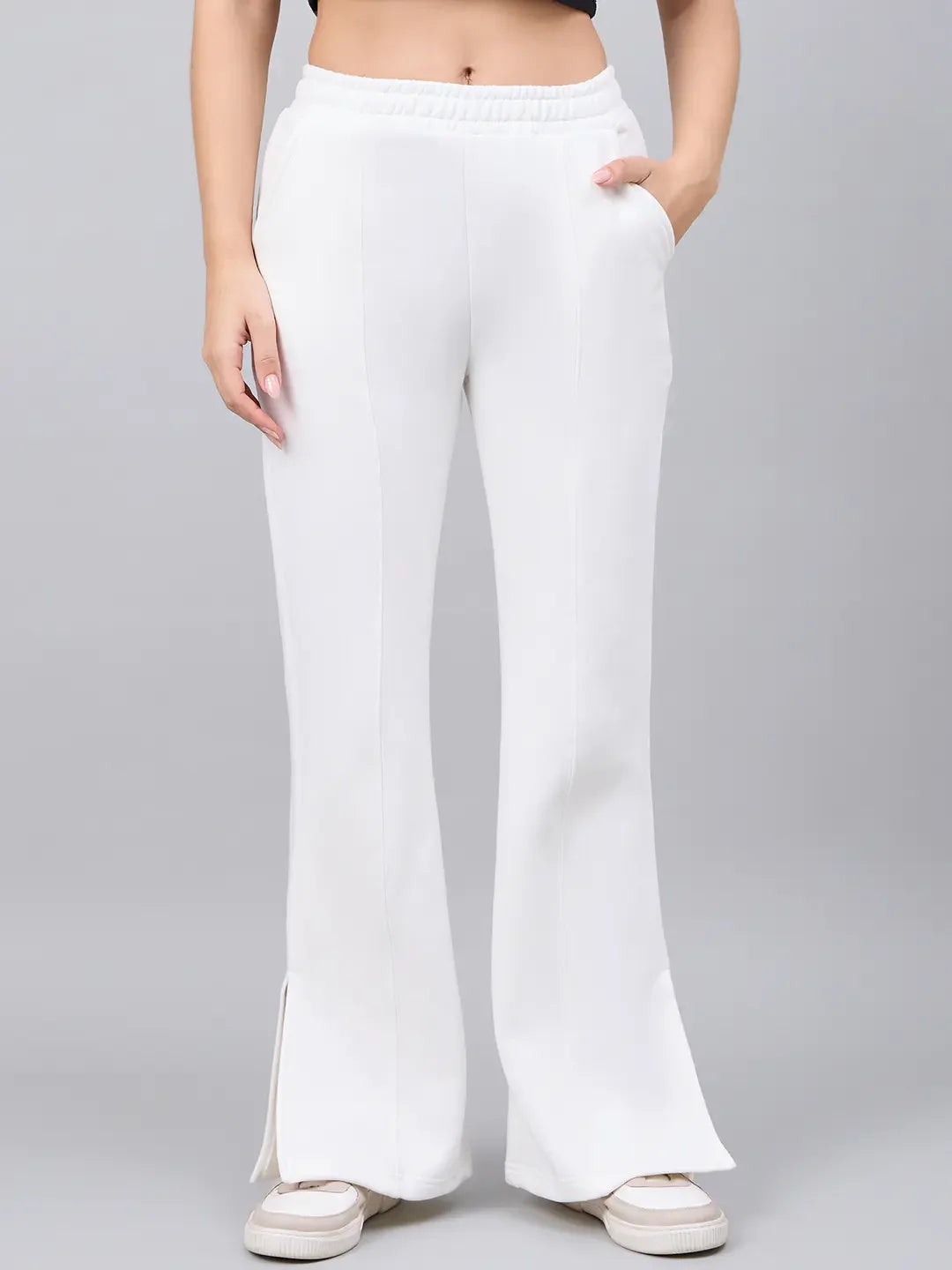 Model wears 98degreenorth Women’s Off-White Bootcut Sweatpants with flared high-waist, styled with white sneakers.