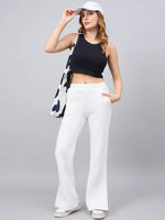 Woman in a black crop top, white sneakers, cap, 98degreenorth tote, and off-white flared high-waist sweatpants.