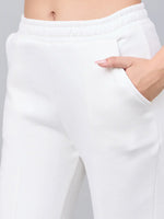 Close-up of waist and hips in 98degreenorth Women’s Off-White Bootcut Sweatpants with side slit, hand in pocket.