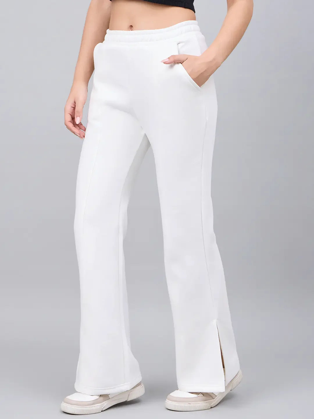 Woman in 98degreenorth Off-White Bootcut Sweatpants, white sneakers, and a black crop top.