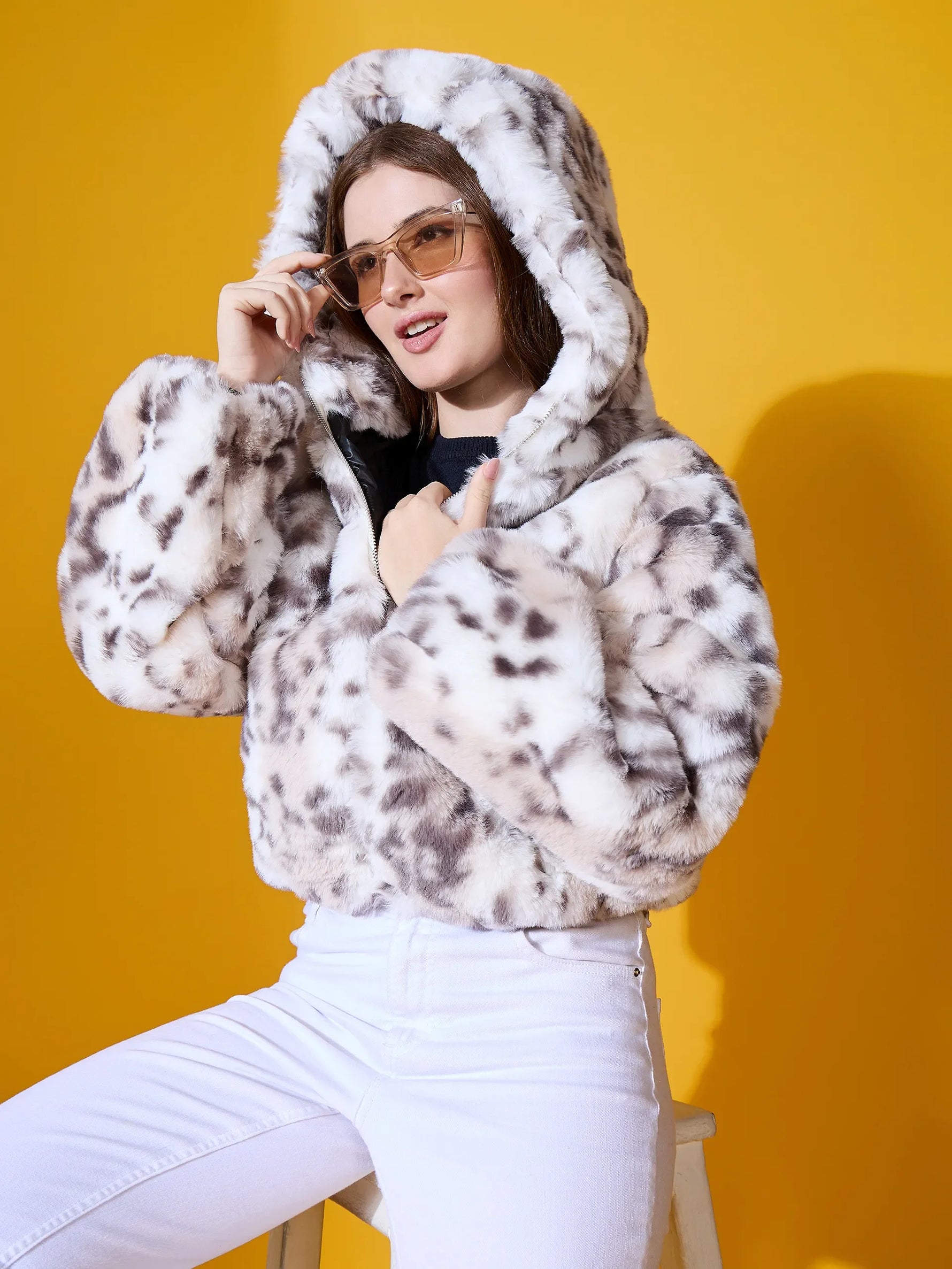Model wears the 98degreenorth Women’s Off-White Faux Fur Jacket, premium winter outerwear, against a yellow backdrop.