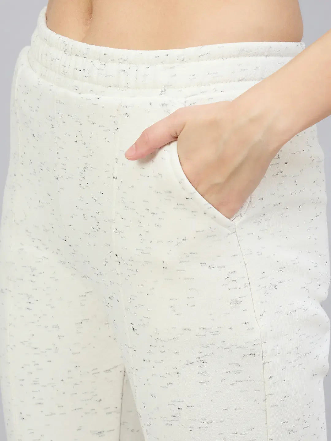 Close-up of a person wearing 98degreenorth’s off-white hairy texture bootcut sweatpants, highlighting waistband and hip.