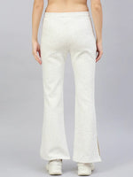A person wears 98degreenorth Women's Off-White Hairy Texture Bootcut Sweatpants with side slit and white sneakers, back view.