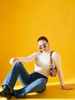 Woman in sunglasses and jeans wears 98degreenorth’s Off-White Ribbed Turtleneck Sweater, posing with a checkered handbag.