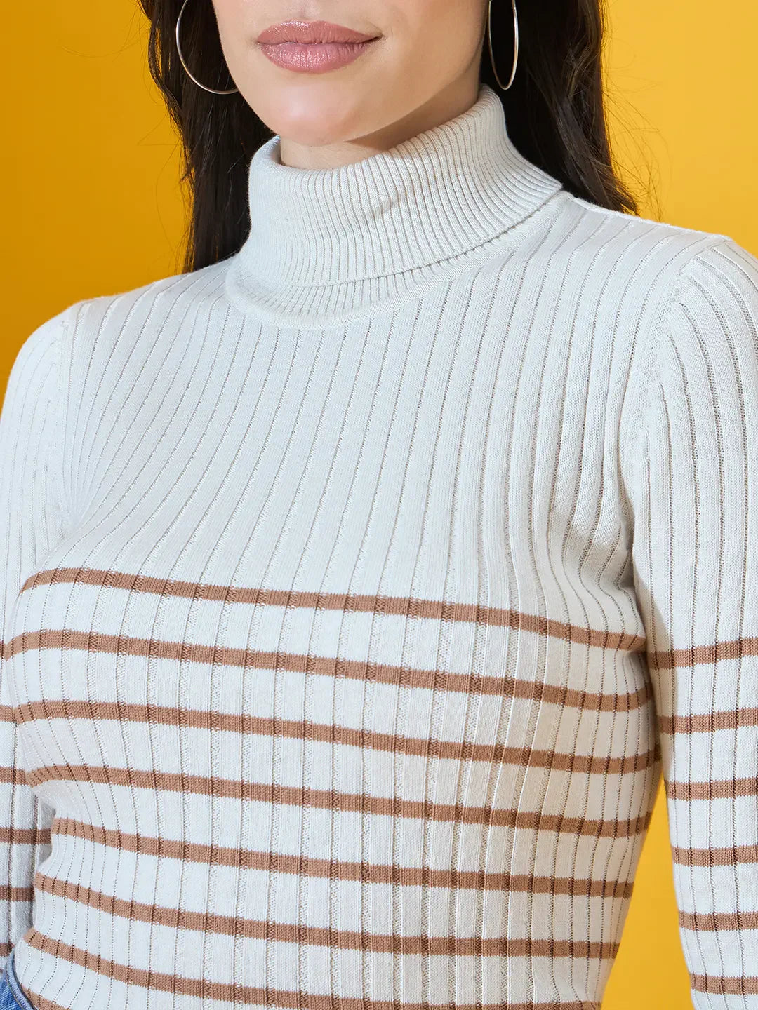 Woman wears 98degreenorth Women’s Off-White Ribbed Turtleneck Sweater, standing against a yellow background.