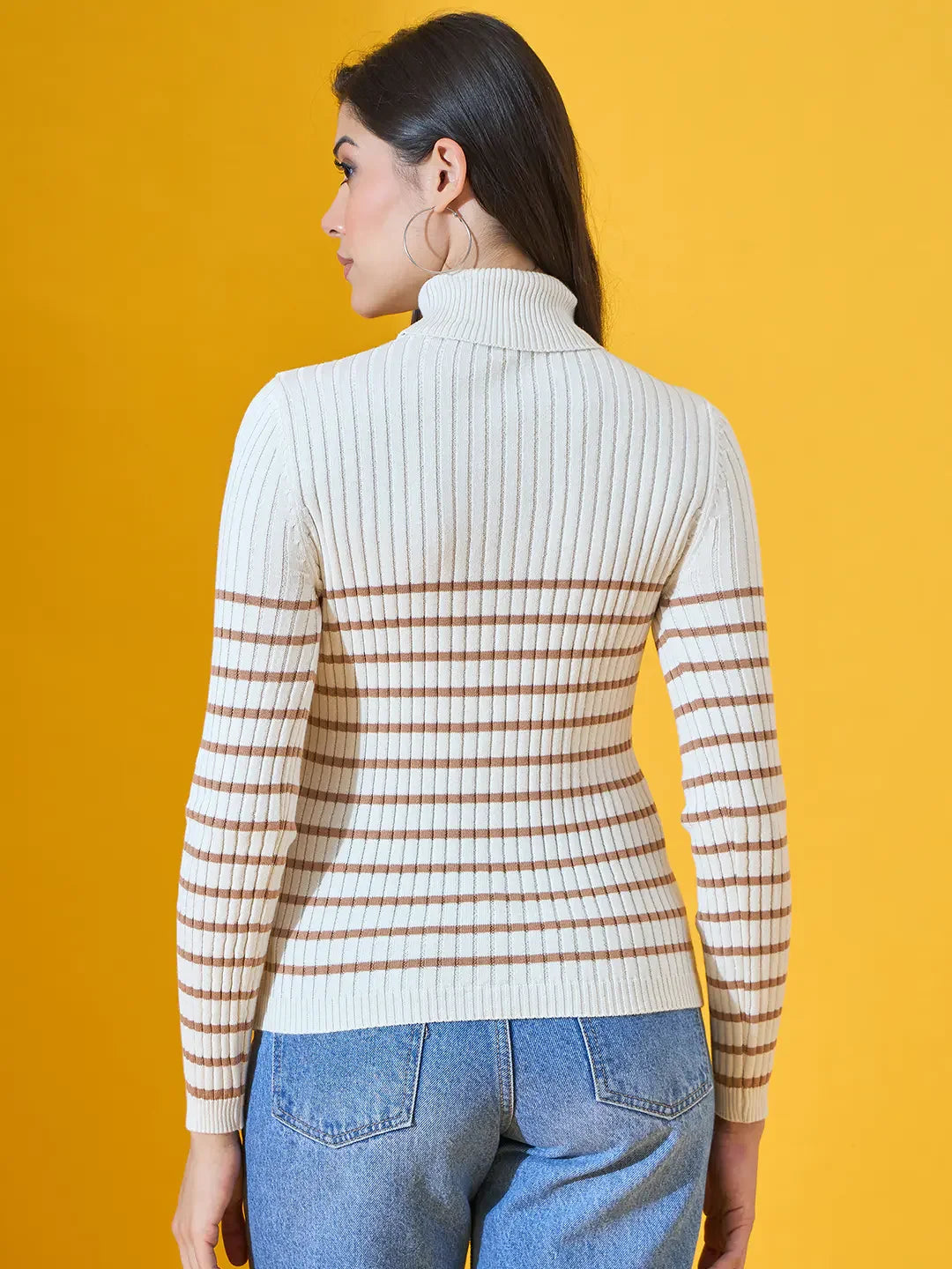 Woman wears a 98degreenorth Off-White Ribbed Turtleneck Sweater with blue jeans, shown from the back on yellow.