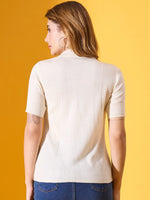 Woman in 98degreenorth off white slim fit ribbed turtle neck sweater and jeans, facing away against a yellow background.