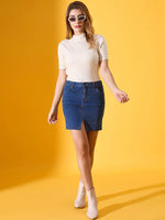 Woman wears 98degreenorth Off White Ribbed Turtle Neck Sweater with denim skirt against a vibrant yellow backdrop.