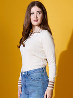 A woman in a 98degreenorth off-white striped collar knit sweater and blue jeans stands against a yellow background.