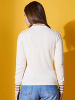 A woman in a 98degreenorth off-white striped collar knit sweater and blue jeans stands with her back to a yellow background.