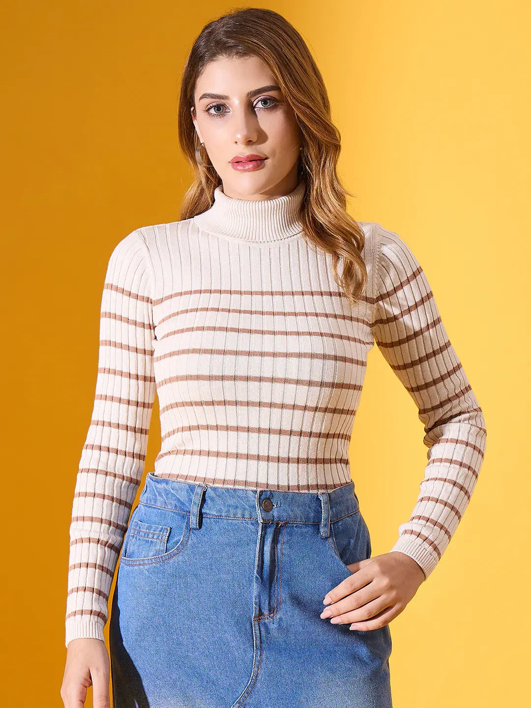 Woman in a 98degreenorth off-white striped ribbed turtleneck sweater and blue denim skirt against a yellow background.
