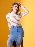 Smiling woman in 98degreenorth's off-white striped ribbed turtleneck sweater poses on a stool, sunglasses in hand.