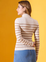 Woman in an off-white 98degreenorth striped ribbed turtleneck sweater and blue jeans, facing away on yellow.