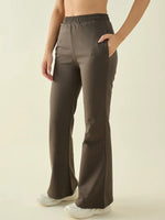 A person wears 98degreenorth Women's Olive Flared Bootcut Cotton Stretchable Trousers with hands in pockets and sneakers.