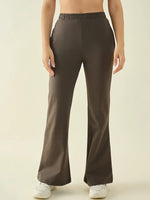 A person in 98degreenorth Women’s Olive Flared Bootcut Cotton Stretchable Trousers, waist to feet, plain background.