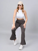 Woman in 98degreenorth Women's Olive Green Bootcut Sweatpants and cap poses stylishly on a white cube.