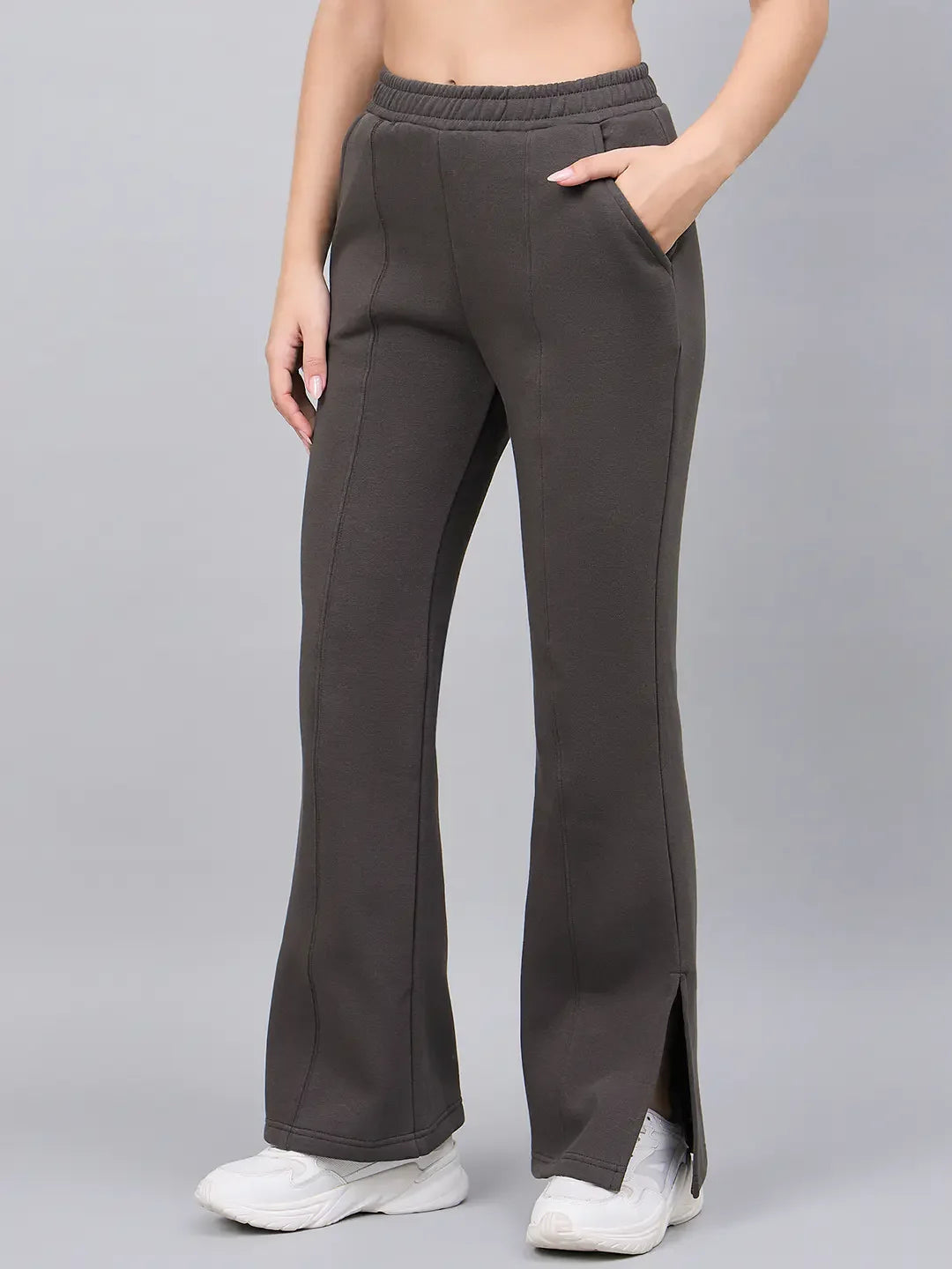 Woman wears 98degreenorth Olive Green Bootcut Sweatpants with side slits, styled with white sneakers.