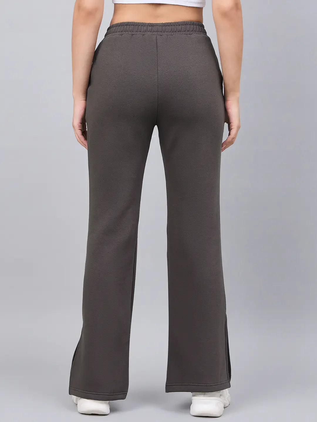 Model wearing 98degreenorth Women’s Olive Green Bootcut Sweatpants with white sneakers, shown from the back.