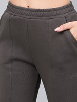 Close-up of 98degreenorth Women’s Olive Green Bootcut Sweatpants, flared with side slits and a hand in the pocket.