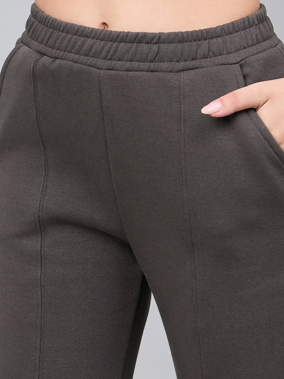 Close-up of 98degreenorth Women’s Olive Green Bootcut Sweatpants, flared with side slits and a hand in the pocket.