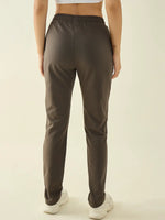 Woman in 98degreenorth Olive Regular Fit Cotton Stretchable Trousers and white sneakers, back view on light backdrop.