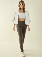 Woman in white crop top, jacket, 98degreenorth Olive Cotton Stretchable Trousers, white sneakers, and sunglasses posing confidently.