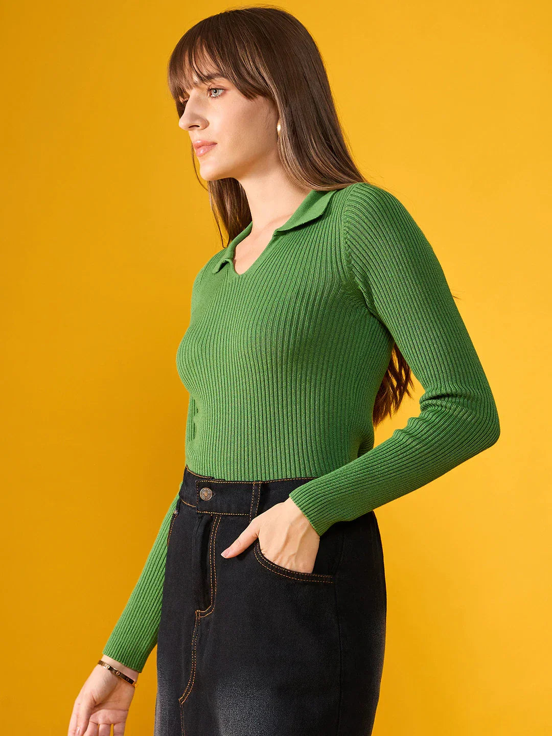 Woman wears 98degreenorth Parrot Green Ribbed Collar Sweater with black jeans, standing against a yellow background.