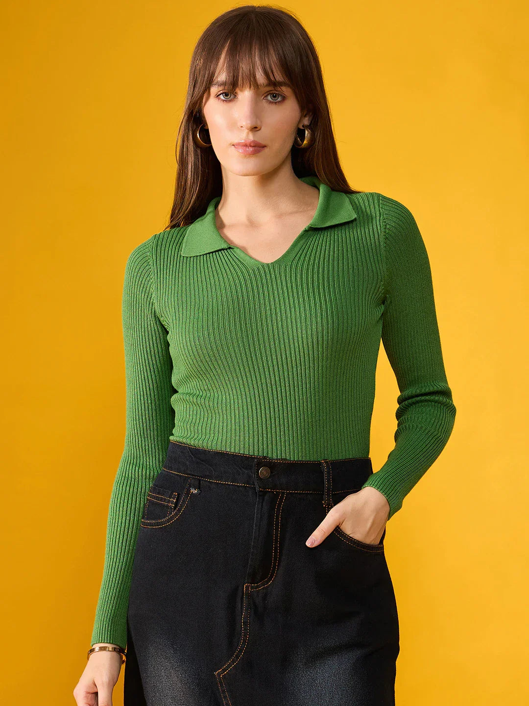 Woman wears 98degreenorth’s Parrot Green Ribbed Stretchable Sweater, standing against a bright yellow background.