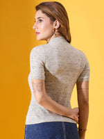 Woman in 98degreenorth’s pista green ribbed turtleneck slim fit half sleeve sweater, standing against a yellow background.