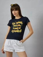 Woman poses confidently in 98degreenorth’s pure cotton printed typography t-shirt, styled with white shorts.