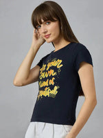 Woman in 98degreenorth pure cotton t-shirt with Be your own kind of beautiful yellow print, street-ready style.