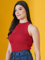 Smiling woman in 98degreenorth’s red ribbed halter neck sleeveless knit top, with jeans, on yellow background.
