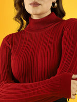 Woman in a 98degreenorth red ribbed turtleneck sweater, gold hoops, and lipstick, posing by a yellow backdrop.