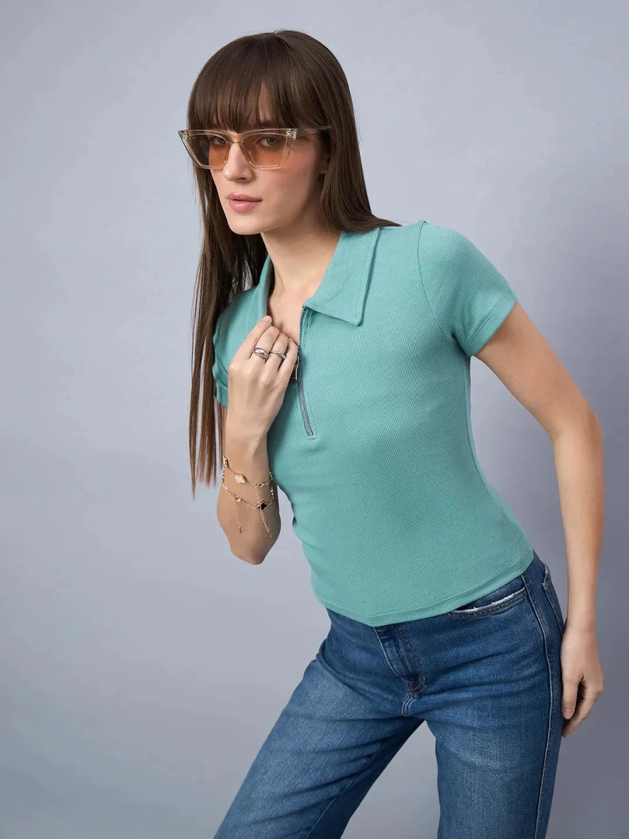Model in 98degreenorth Women's Ribbed Half-Zip Polo Top - Sea Green poses against a plain gray background.