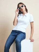 Woman in a 98degreenorth Ribbed Half-Zip Polo Top—white, short sleeve crop—styling minimalist fashion.