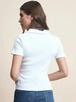 Woman in 98degreenorth’s Women's Ribbed Half-Zip Polo Top - White, styled with blue jeans for a minimalist look.