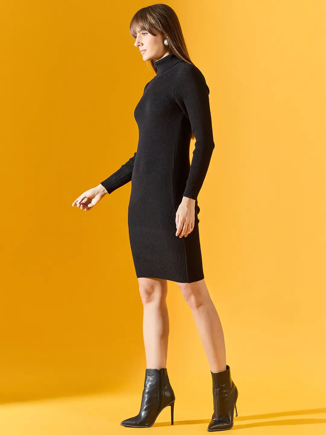 Woman in 98degreenorth's black ribbed bodycon turtleneck dress exudes effortless winter style against a yellow background.
