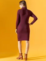 A woman in a 98degreenorth ribbed burgundy turtleneck sweater dress and brown boots stands against a yellow background.