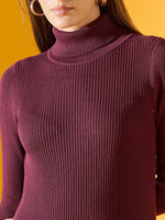 A woman models a 98degreenorth burgundy ribbed bodycon turtleneck sweater dress against a yellow background.
