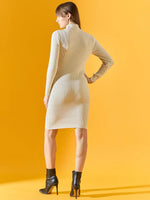 Woman in off-white ribbed bodycon turtleneck dress by 98degreenorth, facing away on a yellow backdrop.