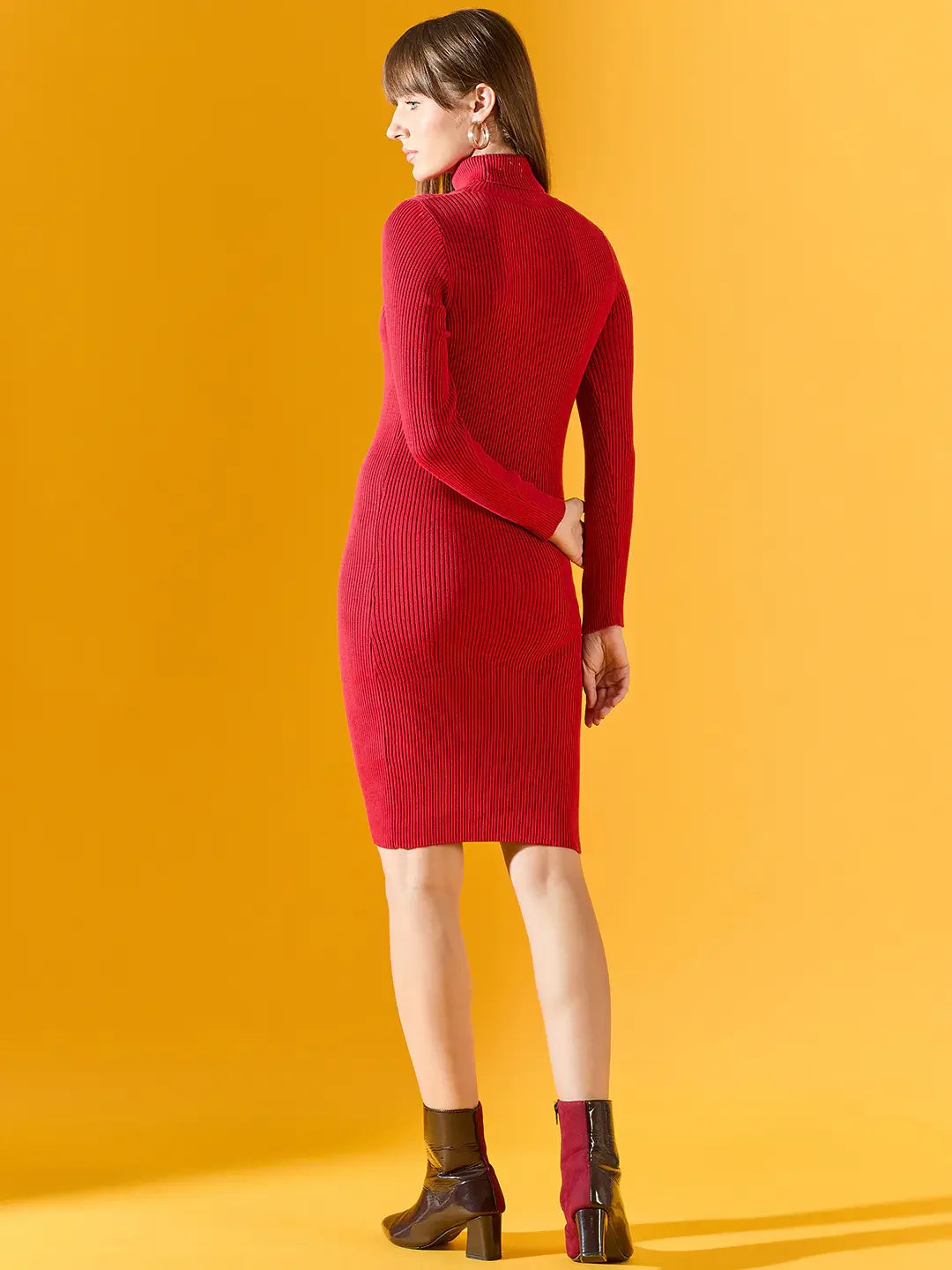 Woman wearing 98degreenorth Women’s Ribbed Knitted Bodycon Dress in red stands against a yellow background, facing away.