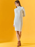 Woman in a 98degreenorth Ribbed Knitted Bodycon White Sweater Dress and brown ankle boots on a yellow background.