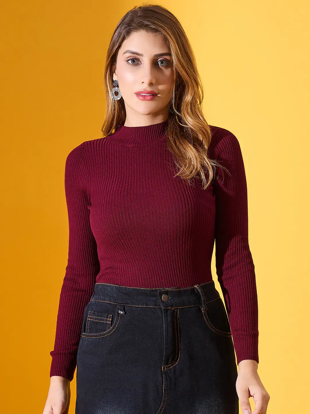 A woman models 98degreenorth’s Rosewood Ribbed High-Neck Sweater, chic winter style for India, against yellow.