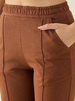 Close-up of a person wearing 98degreenorth Women’s Rust Straight Fit Cotton Stretchable Trousers with stitched seam details.